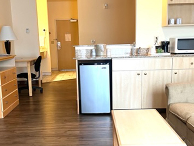 Living area with couch, TV, mini fridge and table