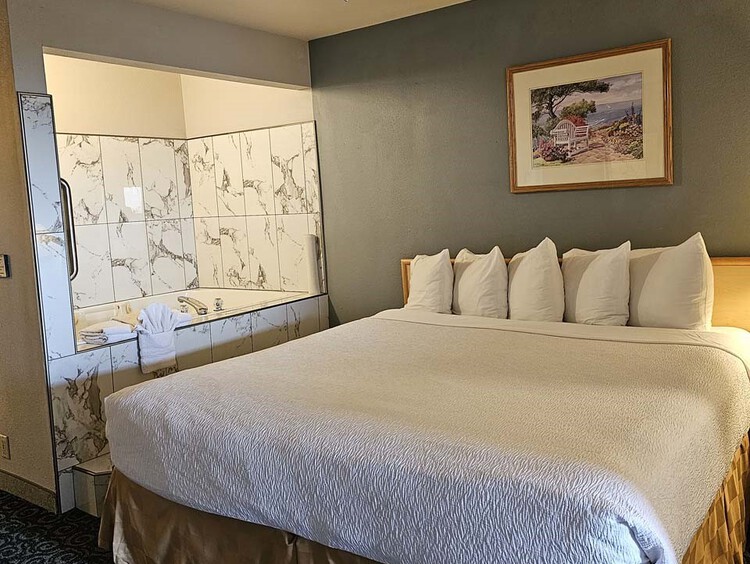 King bed, night table, and jacuzzi tub