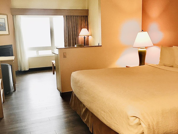 King bed with lamp and wooden floors