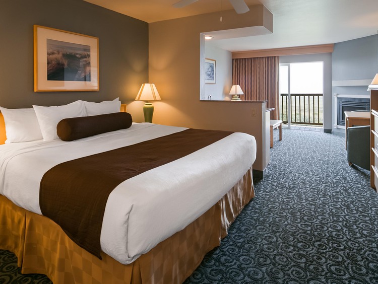 King bed with work desk and view of balcony