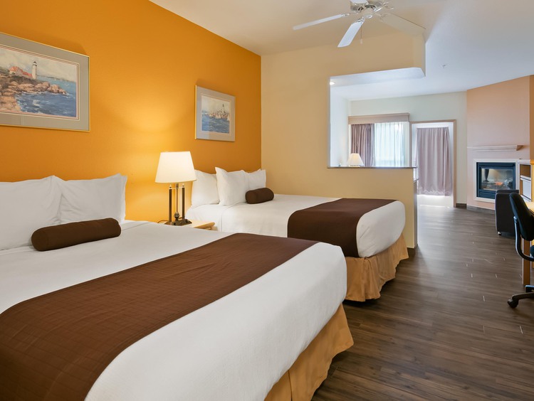 Two queen beds with work desk and orange wall