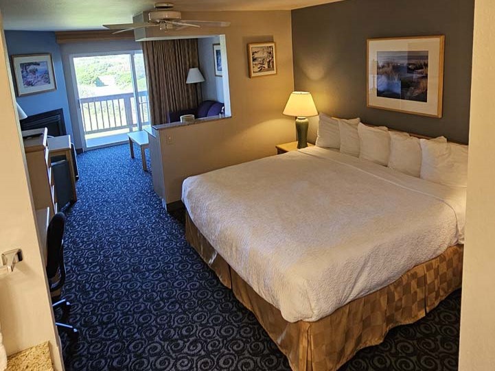 King bed with work desk and view of balcony