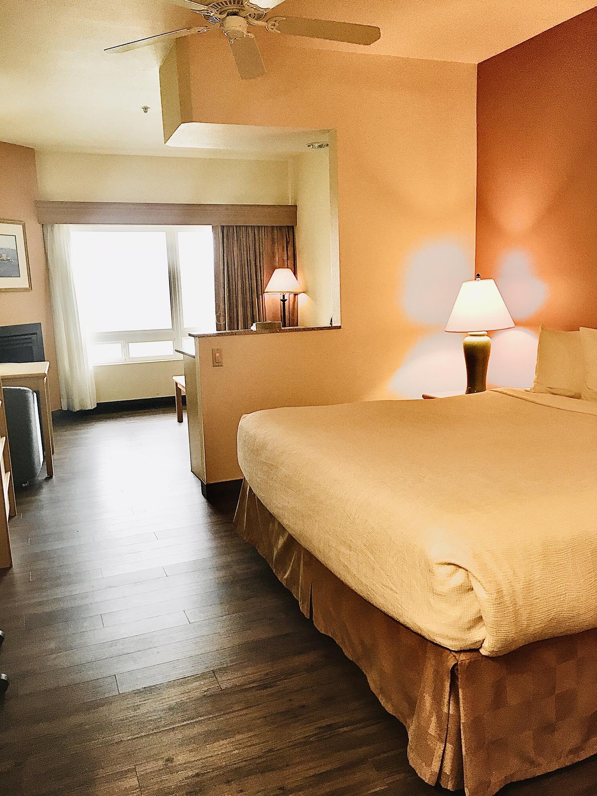 King bed with lamp and wooden floors